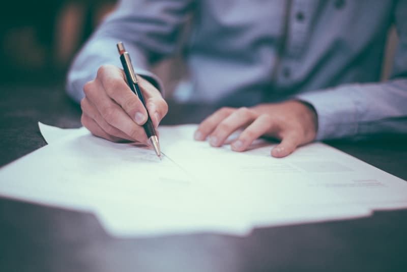 Person som signerer et dokument med penn